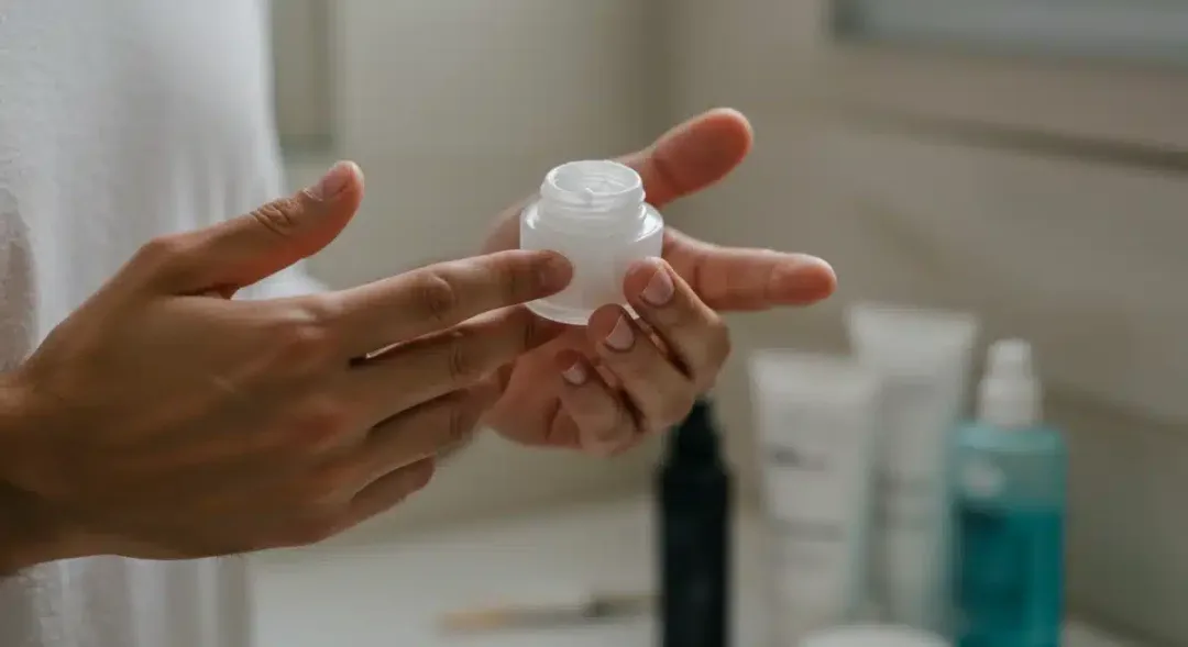 Man applying face moisturizer as part of his skincare routine